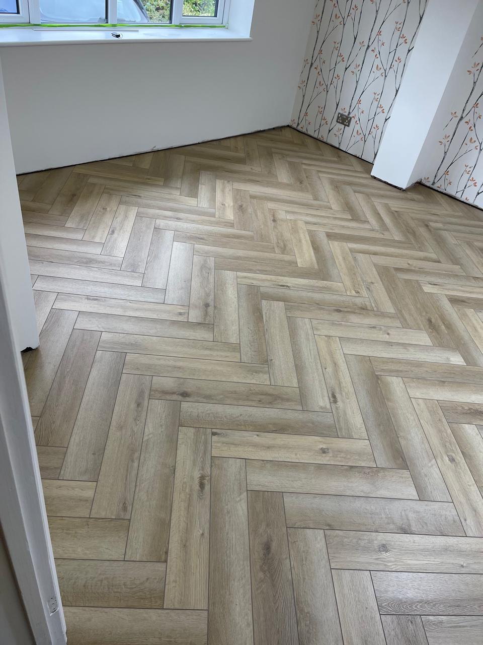 Laminat herringbone i lehtë në dhomë me tapiceri