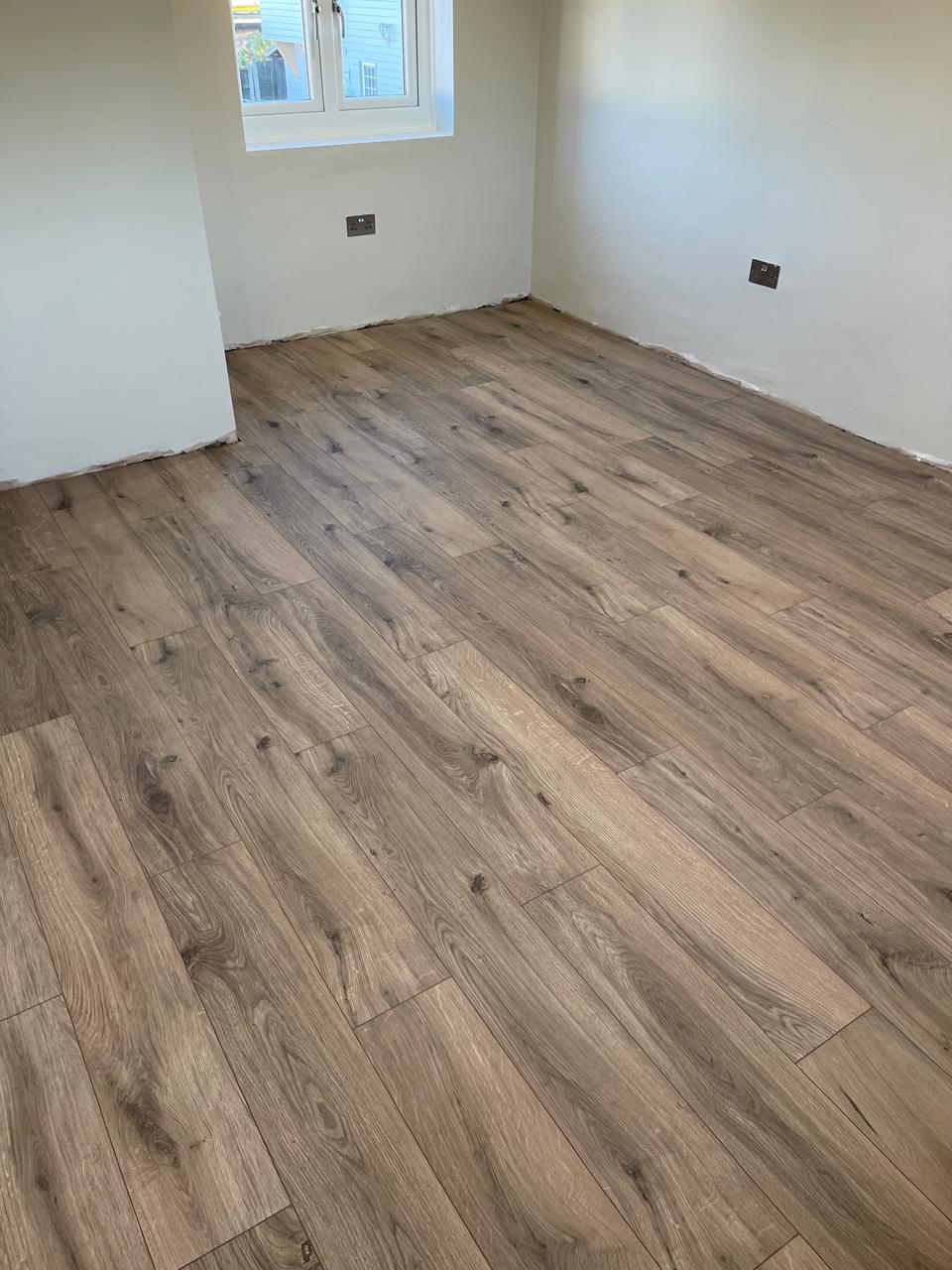 Laminat druri në dhomë me radiator dhe dritare