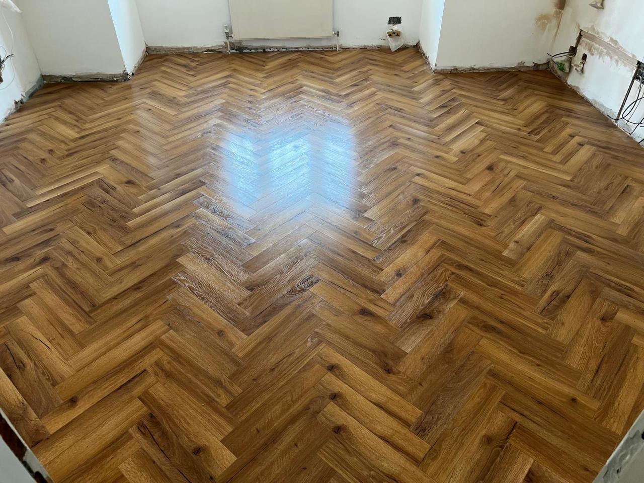 Parket herringbone lisi i ri në dhomë bosh