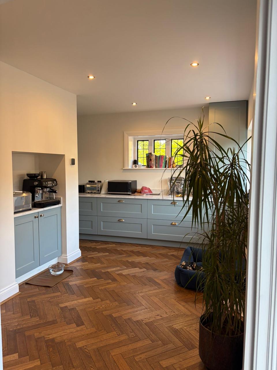 Herringbone i errët lisi në kuzhinë blu shaker