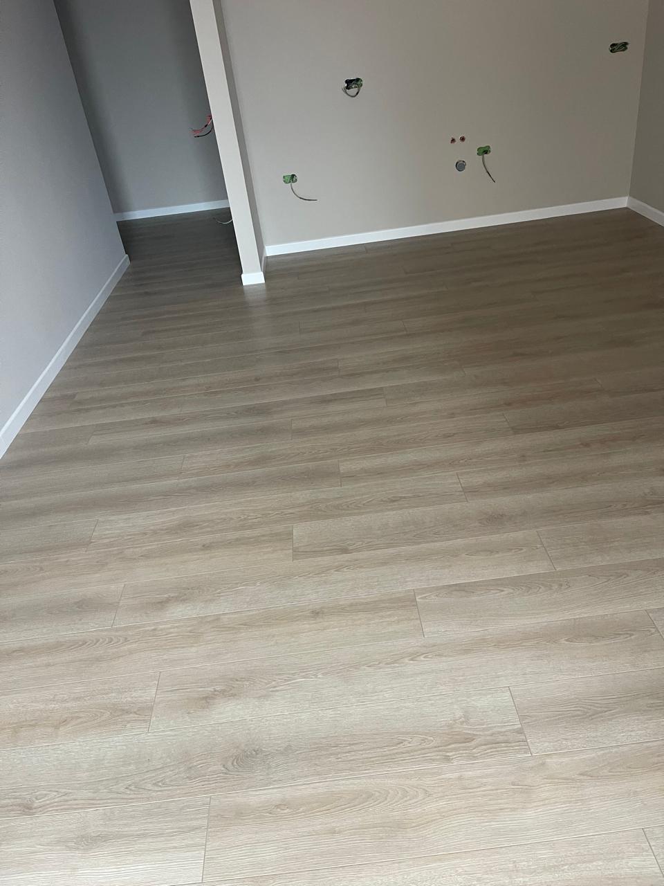 Laminat lisi gri i lehtë në dhomë të re