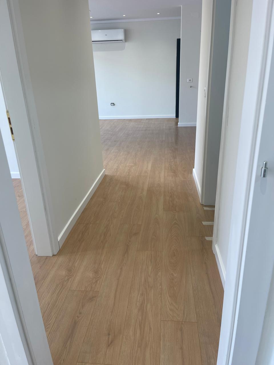 Laminat lisi në korridor që çon në sallon